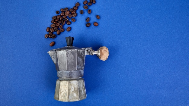 Cafetière et grains de café sur fond de tendance bleue