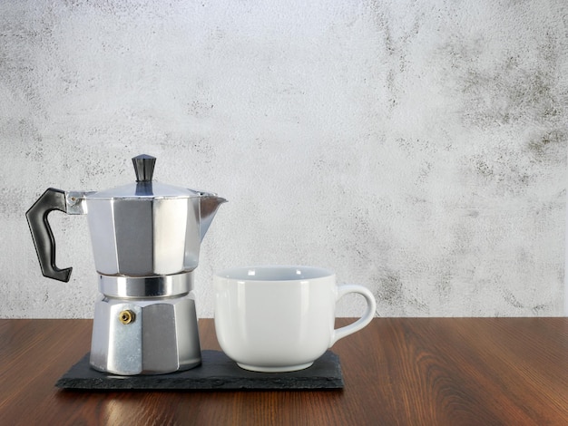 Cafetière moka et une tasse sur une table en bois