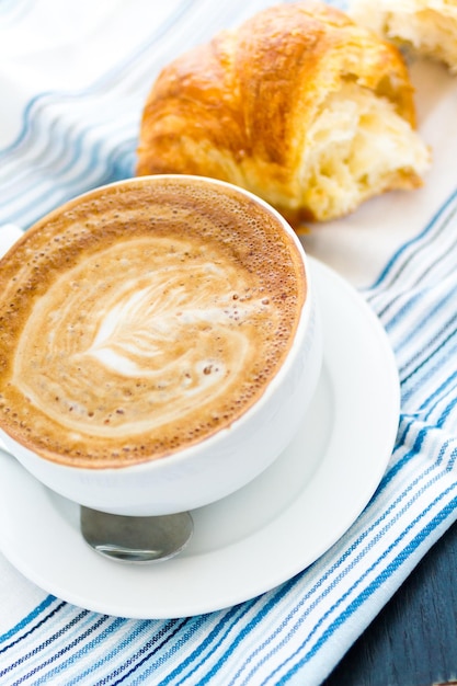 Caffe latte gastronomique avec motif de feuilles en mousse.