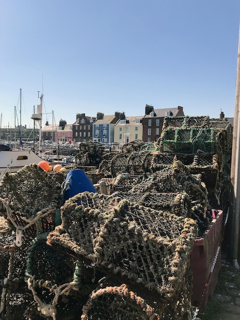 Des cages spéciales pour attraper des homards et des crabes sont empilées dans le port en arrière-plan