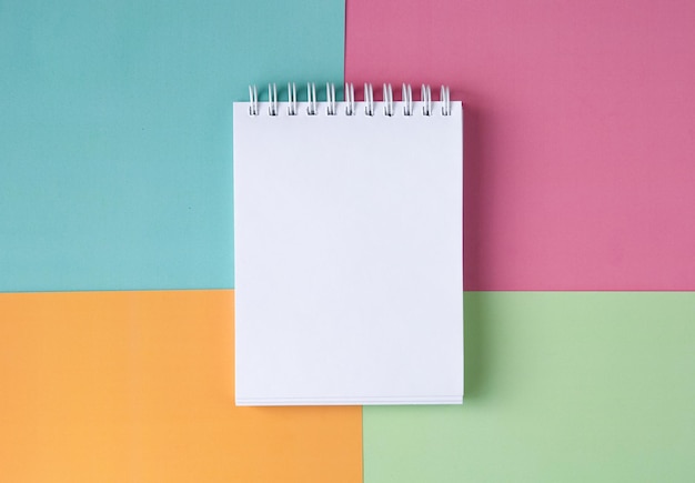 Cahier blanc sur fond multicolore