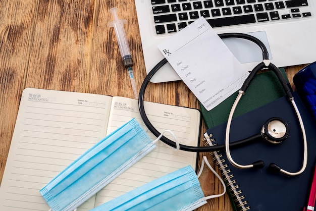 Cahier blanc avec prescription de stéthoscope du médecin sur clavier noir avec masques de cahier sur la table Concept de médecine