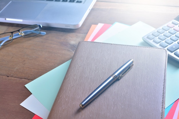 Cahier avec calculatrice, clavier et stylo sur table