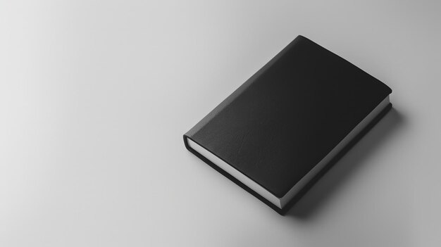 Un cahier avec une couverture noire sur un fond blanc