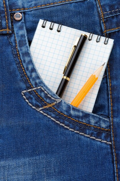 Cahier et crayon sur paquet de jeans