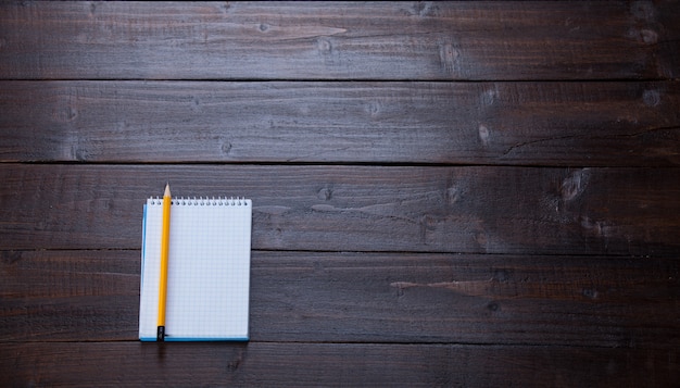 Cahier et un crayon sur une table en bois.