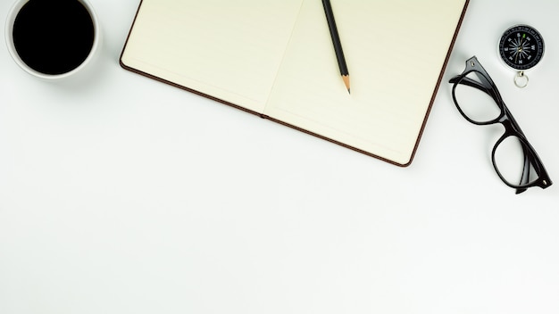 Cahier en cuir marron et une tasse de café sur fond de bureau blanc avec espace de copie. - fournitures de bureau ou concept d’éducation.