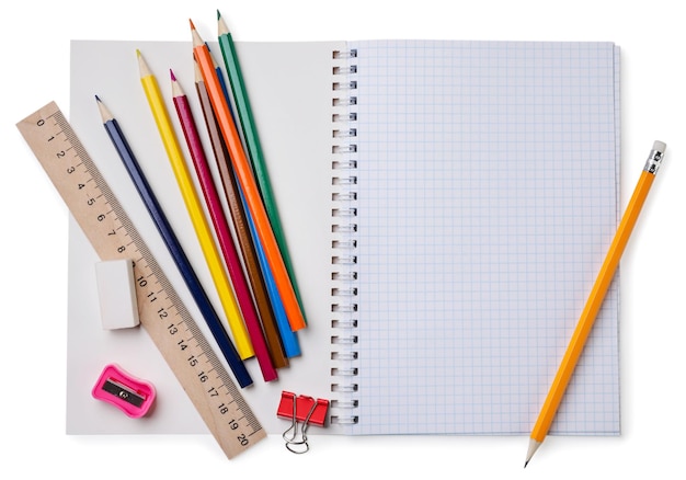 Cahier d'école avec des crayons de couleur et une règle sur fond blanc Vue de dessus Place pour le texte