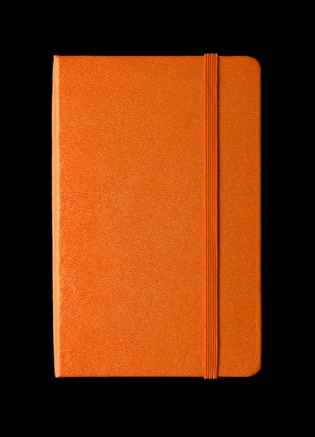 Cahier fermé orange isolé sur fond noir