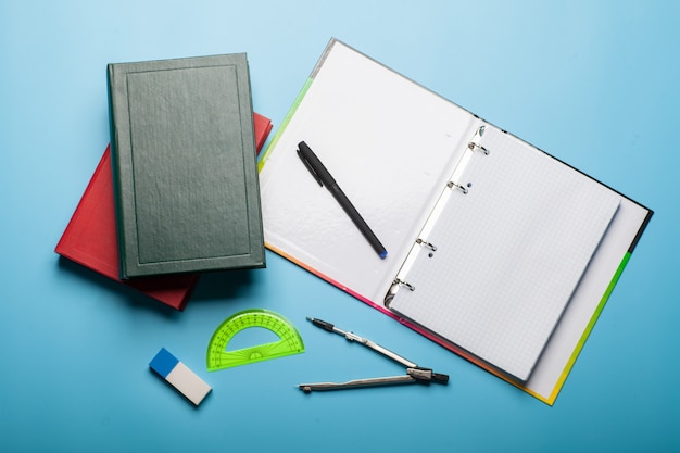 Cahier, livres, stylo et règle, concept d'éducation isolé