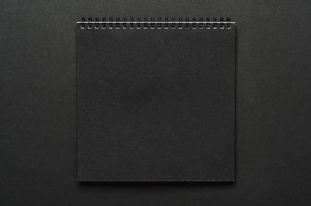 Cahier noir sur une spirale sur un tableau noir.