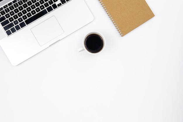 Cahier d'ordinateur portable et une tasse de café noir sur une vue de dessus de fond blanc