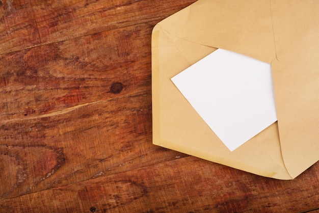 Cahier organique enveloppe postale ouverte avec du papier propre sur l'espace de copie de fond en bois isoler Gros plan Vue de dessus