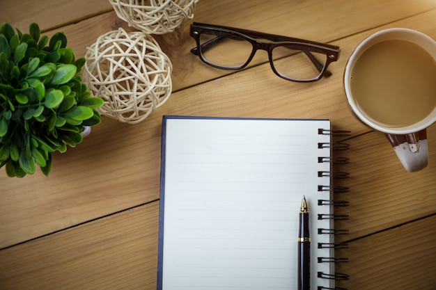 cahier avec des pages blanches sur une table en bois.