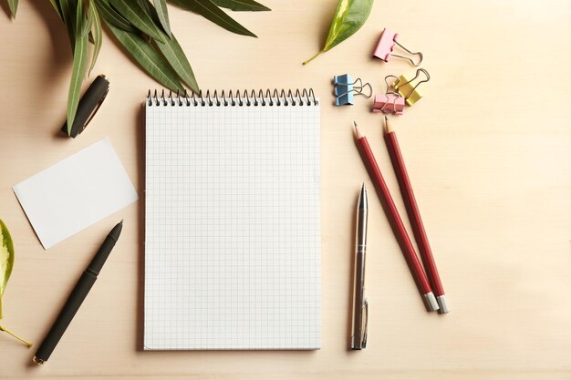 Cahier et papeterie sur fond de bois beige