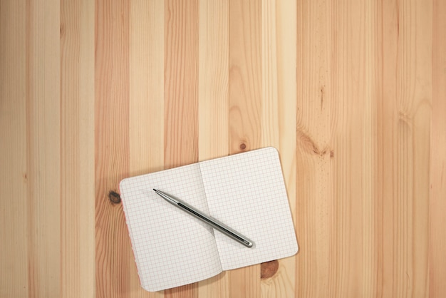 Cahier en papier blanc sur le bureau en bois avec vue de dessus pour le fond ou la toile de fond