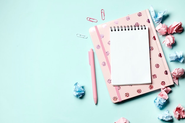 Cahier rose sur fond bleu avec fournitures scolaires. Retour à l'école. Le jour du professeur.