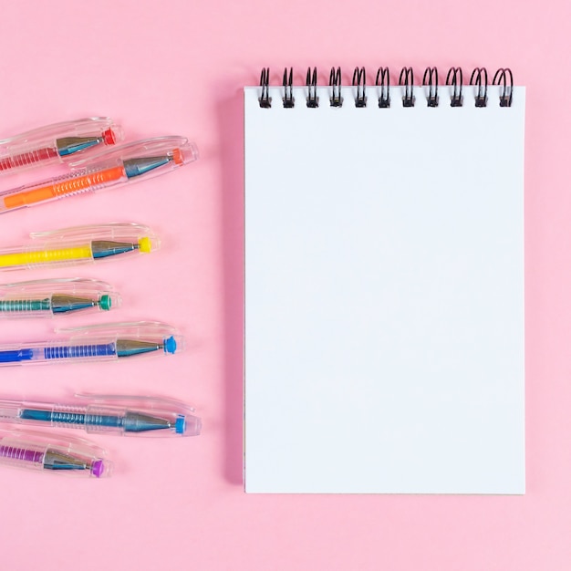 Cahier sur une spirale avec des feuilles vierges sur un rose.