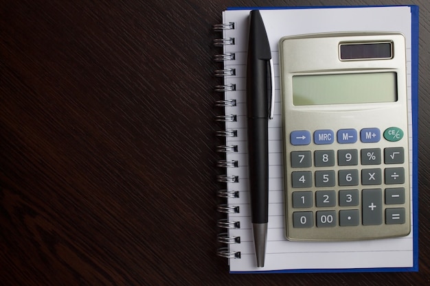 Cahier avec stylo et calculatrice.