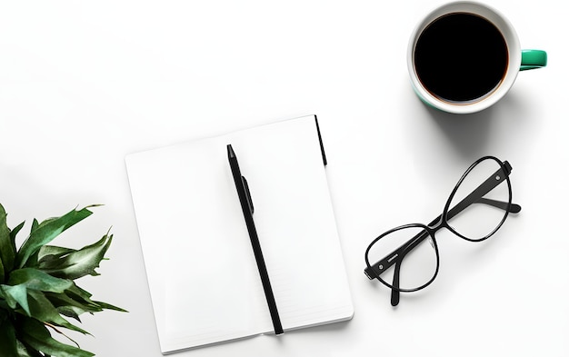 Un cahier avec un stylo et des lunettes dessus et une plante sur la table.