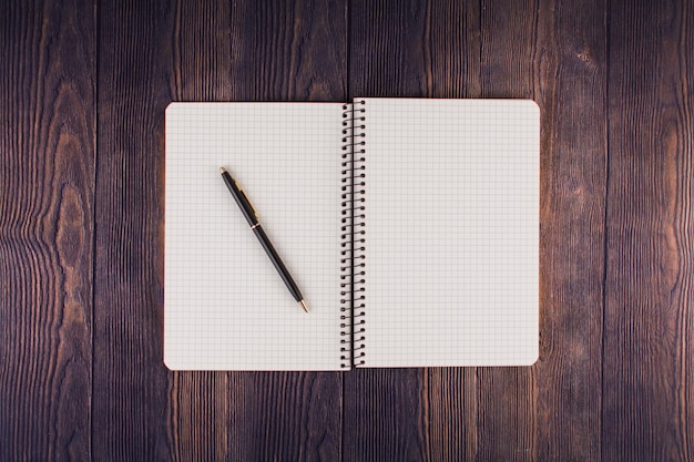 Cahier avec stylo sur une table en bois