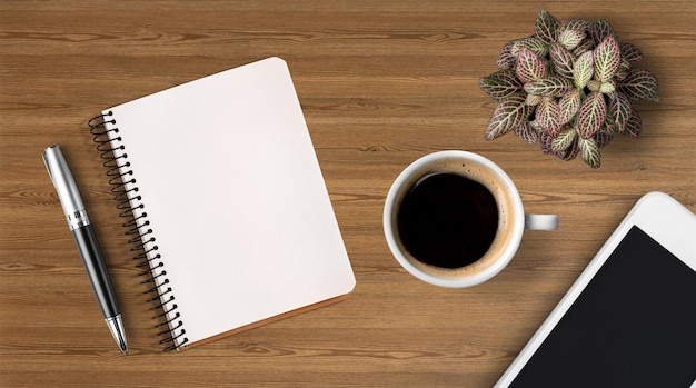 Cahier et tasse de café fort sur fond en bois.