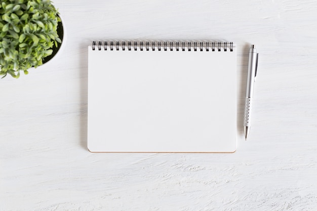 cahier vide ouvert sur une table en bois blanc