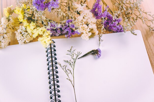 Cahier Vierge Blanche De Fleur De Fleur Et Blanc Sur La Table En Bois