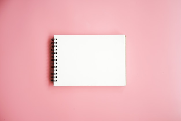 Cahier vierge sur fond rose