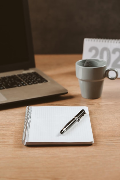 Cahier vierge avec un stylo un calendrier un cahier et un concept de café chaud objectifs et plan d'action nouvel an