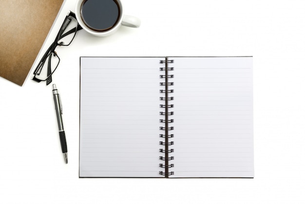 Cahier vierge, stylo et papier brun sur le bureau blanc