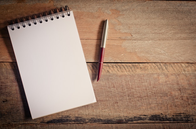 cahier vierge avec un stylo sur la table en bois - nature morte