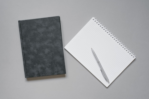 Photo cahiers et agendas sur un bureau gris avec un stylo