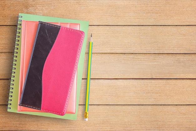 Cahiers et crayon sur un bureau ou une table en bois