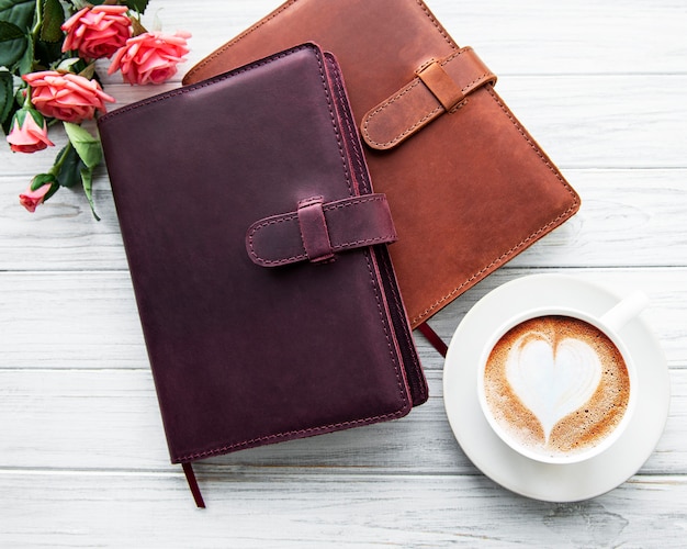 Cahiers en cuir et tasse de café