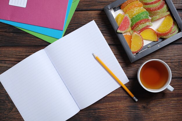 Cahiers d'école, tasse de thé et marmelade colorée