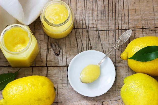 Caillé de citron fait maison avec des pots et des citrons sur fond en bois