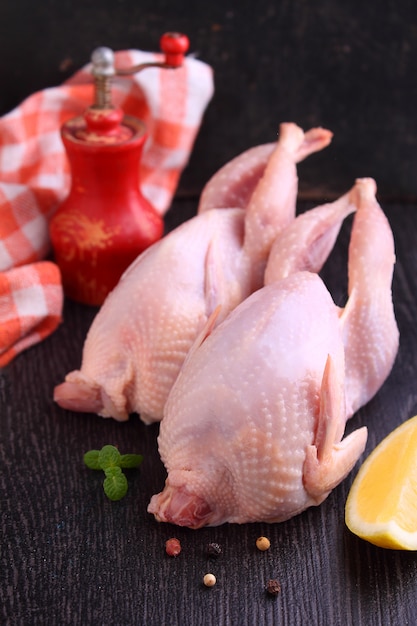 Caille crue au citron, légumes et épices dans un plat allant au four