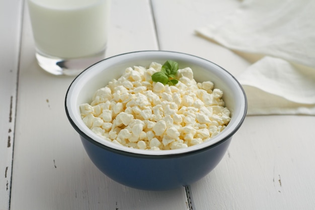 Caillé de fromage cottage dans un bol brun sur fond de bois