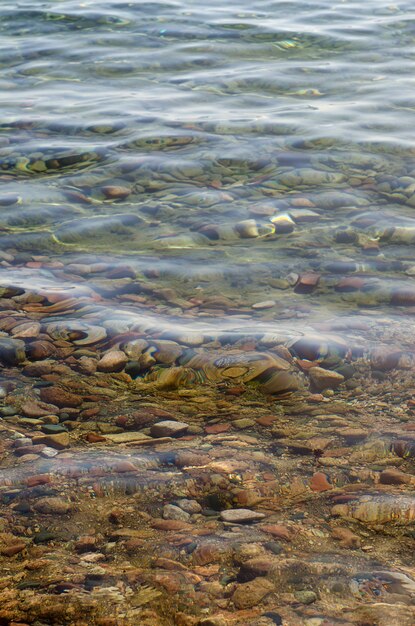 Cailloux colorés dans l'eau cristalline.