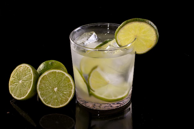 Caipirinha brésilienne avec de la glace et du citron dans un verre dans une photo de studio