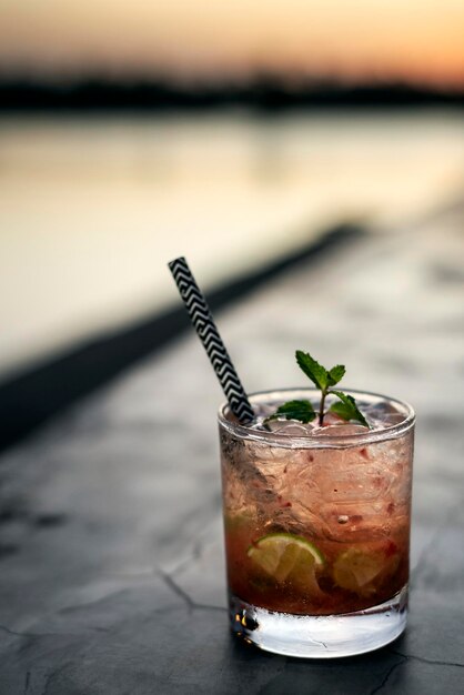 Caipirinha à la fraise, cocktail mixte dans un bar en plein air au coucher du soleil