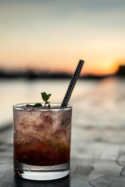 Caipirinha à la fraise, cocktail mixte dans un bar en plein air au coucher du soleil