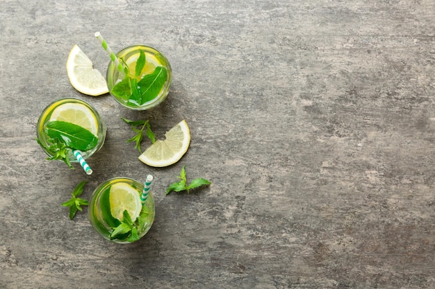 Caipirinha Mojito cocktail vodka ou boisson gazeuse à la menthe citron vert et paille sur fond de table Boisson rafraîchissante à la menthe et citron vert en vue de dessus en verre à plat