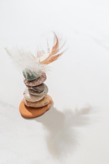 Cairn avec plume d'oiseau sur fond blanc