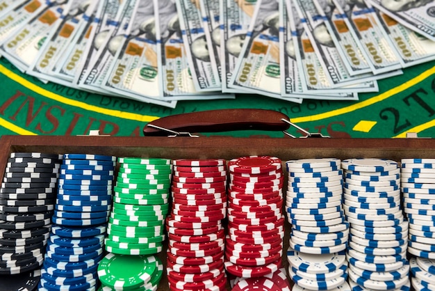 Caisse complète de jetons de poker avec des dollars sur la table de jeu. poker.