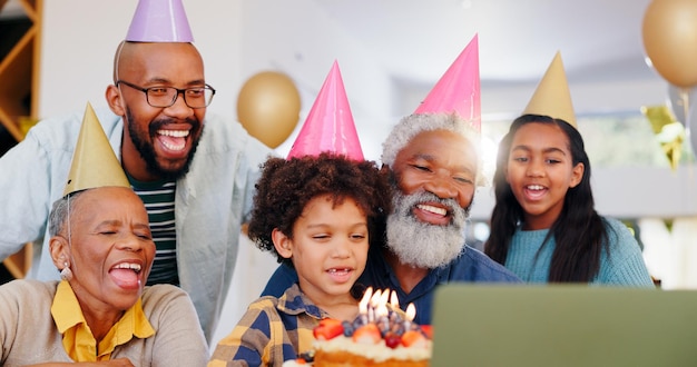 Photo cake appel vidéo et famille à la fête d'anniversaire célébration ensemble à la maison moderne avec des bougies heureux ordinateur portable et les jeunes enfants avec le père africain et les grands-parents pour le dessert sucré à la maison