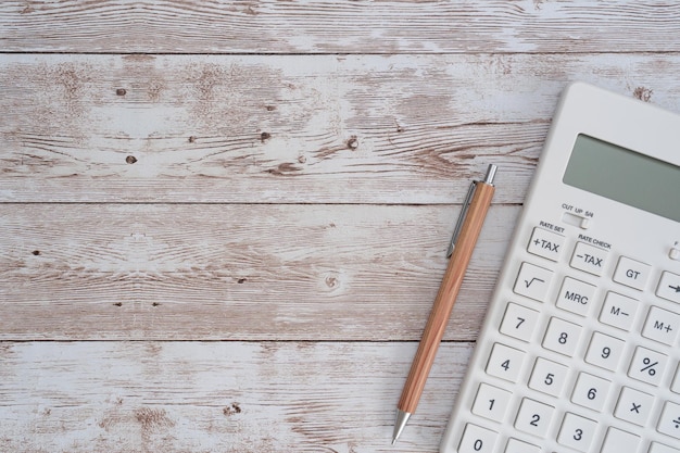 Une calculatrice blanche et un stylo.