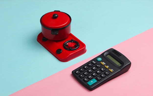 Calculatrice et cuisinière jouet avec casserole sur un pastel bleu-rose