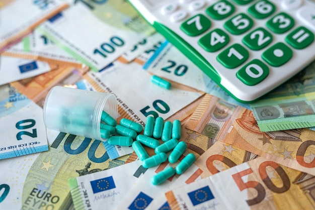 Calculatrice de différentes pilules et billets en euros concept médical pharmacie à coût élevé